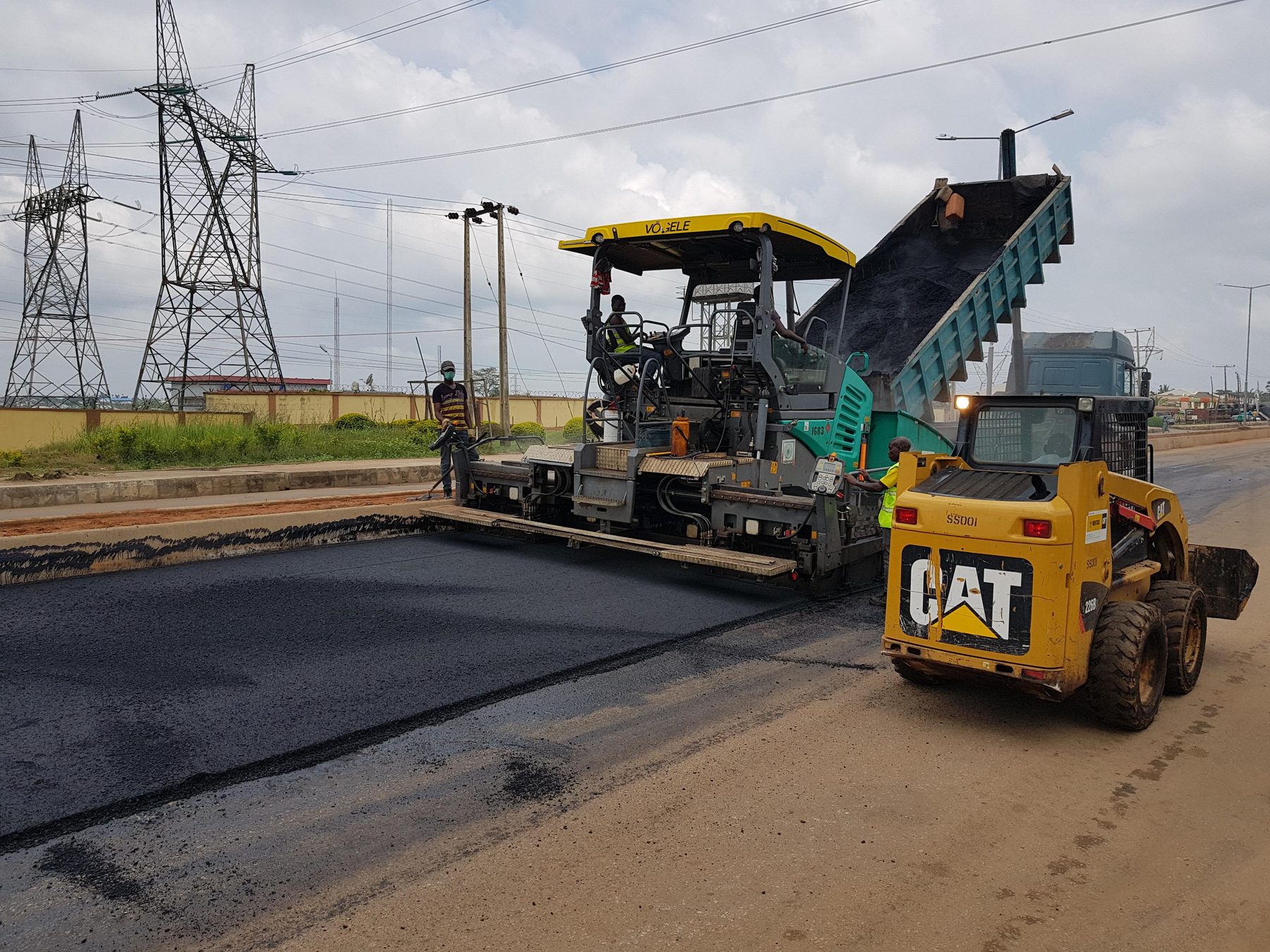 Stesa di conglomerato bituminoso con finitrice in cantiere stradale